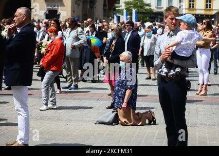 I cattolici celebrano il Corpus Domini partecipando alla Santa Messa e alla processione nella piazza principale durante la pandemia del coronavirus. Cracovia, Polonia il 4 giugno 2021. La processione inizia con un sacerdote che porta un mostrania sotto un baldacchino. I fedeli lo seguono cantando inni religiosi, mentre le giovani ragazze vestite con abiti bianchi o tradizionali regionali spargono petali di fiori lungo il percorso. Il Corpus Christi è una festa cattolica mobile che commemora la Transostituzione. (Foto di Beata Zawrzel/NurPhoto) Foto Stock