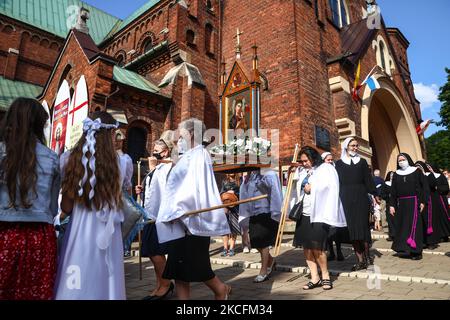 I cattolici celebrano il Corpus Domini partecipando alla Santa Messa e alla processione durante la pandemia del coronavirus. Cracovia, Polonia il 4 giugno 2021. La processione inizia con un sacerdote che porta un mostrania sotto un baldacchino. I fedeli lo seguono cantando inni religiosi, mentre le giovani ragazze vestite con abiti bianchi o tradizionali regionali spargono petali di fiori lungo il percorso. Il Corpus Christi è una festa cattolica mobile che commemora la Transostituzione. (Foto di Beata Zawrzel/NurPhoto) Foto Stock