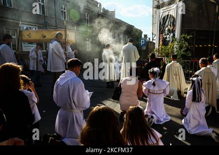 I cattolici celebrano il Corpus Domini partecipando alla Santa Messa e alla processione durante la pandemia del coronavirus. Cracovia, Polonia il 4 giugno 2021. La processione inizia con un sacerdote che porta un mostrania sotto un baldacchino. I fedeli lo seguono cantando inni religiosi, mentre le giovani ragazze vestite con abiti bianchi o tradizionali regionali spargono petali di fiori lungo il percorso. Il Corpus Christi è una festa cattolica mobile che commemora la Transostituzione. (Foto di Beata Zawrzel/NurPhoto) Foto Stock