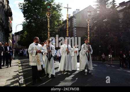 I cattolici celebrano il Corpus Domini partecipando alla Santa Messa e alla processione durante la pandemia del coronavirus. Cracovia, Polonia il 4 giugno 2021. La processione inizia con un sacerdote che porta un mostrania sotto un baldacchino. I fedeli lo seguono cantando inni religiosi, mentre le giovani ragazze vestite con abiti bianchi o tradizionali regionali spargono petali di fiori lungo il percorso. Il Corpus Christi è una festa cattolica mobile che commemora la Transostituzione. (Foto di Beata Zawrzel/NurPhoto) Foto Stock