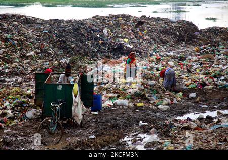 Persone i raccoglitori di rifiuti prelevano i rifiuti non biodegradabili da utilizzare per l'industria del riciclaggio nel sito di discarica a Dhaka, Bangladesh, il 5 giugno 2021. Anche se i normali istinti dei cittadini li impongono di evitare di passare il deposito di rifiuti tossici a tutti i costi, c'è un enorme gruppo di persone che scavano fuori un vivere dalla raccolta di terreni che vendono 'Bhangari' (raccolta di rottami locali). (Foto di Sony Ramany/NurPhoto) Foto Stock