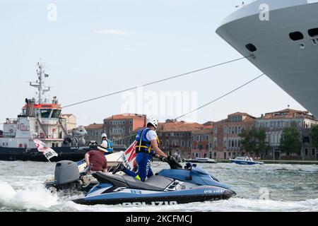 Jet-Sky di polizia davanti alla grande nave che blocca le barche della manifestazione, a Venezia, Italia, il 5 giugno 2021. La gente del posto ha dimostrato oggi contro il transito delle grandi navi e delle navi da crociera a Venezia dopo che il traffico delle grandi navi si è fermato a causa del COVID e dell'assenza di turisti. La grande nave MSC Orchestra ha attraversato il canale della Giudecca scortato dalla polizia su barche e jet-Sky. (Foto di Giacomo Cosua/NurPhoto) Foto Stock