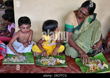 I devoti indù tamil mangiano un tradizionale pranzo vegetariano servito su una foglia di banana seguendo le preghiere durante il 108 abhishekam pooja onorando Lord Vinayagar (Lord Ganesh) al tempio di Arasadi Vinayagar (Arasadi Sithi Vinayagar Kovil) a Jaffna, Sri Lanka. (Foto di Creative Touch Imaging Ltd./NurPhoto) Foto Stock