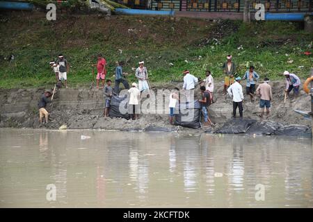 I lavoratori hanno messo i sacchi di sabbia sulla riva del fiume Brahmaputra per controllare l'erosione del suolo prima della stagione monsonica, a Guwahati, in India, il 8,2021 giugno. (Foto di Anuwar Hazarika/NurPhoto) Foto Stock