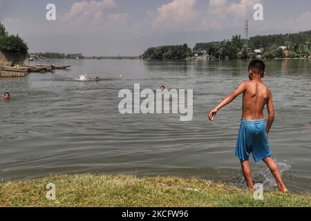 I ragazzi di Kashmiri si raffreddano nel fiume Jehlum per battere il caldo in una calda giornata estiva nella città di Sopore del distretto di Baramulla, circa 60Kms km da Srinagar a Jammu e Kashmir, India il 09 giugno 2021. Mentre la prima ondata di caldo in corso dell'anno in Kashmir dovrebbe continuare per i prossimi due giorni, il monsone dovrebbe colpire la regione e portare piogge leggere a partire dal giugno 11. (Foto di Nasir Kachroo/NurPhoto) Foto Stock