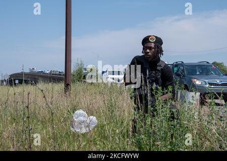 Un membro del Young Black Panther Party fornisce dettagli di sicurezza per il 5th giugno 2021 Stop Racial Profiling march lungo 8 Mile Road a Detroit, MI. (Foto di Adam J. Dewey/NurPhoto) Foto Stock