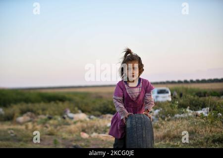 Bambini che giocano con vecchie gomme vicino ad un campo per gli sfollati vicino al villaggio di Nasiriyah al confine con la Turchia il 11 giugno 2021. (Foto di rami Alsayed/NurPhoto) Foto Stock