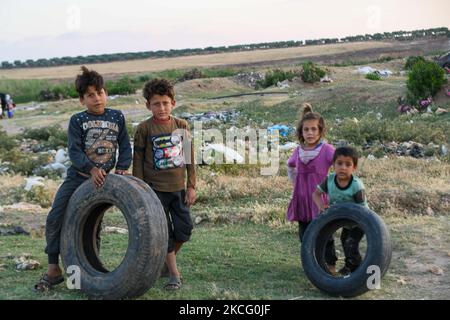 Bambini che giocano con vecchie gomme vicino ad un campo per gli sfollati vicino al villaggio di Nasiriyah al confine con la Turchia il 11 giugno 2021. (Foto di rami Alsayed/NurPhoto) Foto Stock