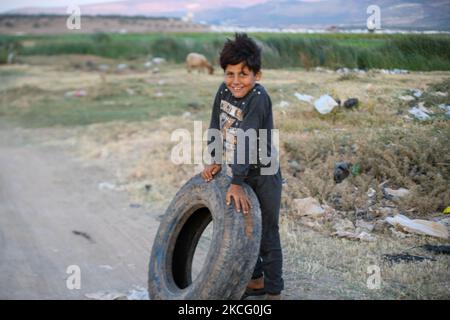 Bambini che giocano con vecchie gomme vicino ad un campo per gli sfollati vicino al villaggio di Nasiriyah al confine con la Turchia il 11 giugno 2021. (Foto di rami Alsayed/NurPhoto) Foto Stock