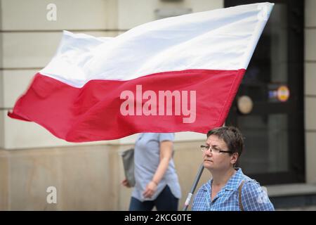 Una donna porta una bandiera polacca durante un raduno anti-vaccinazione a Varsavia, Polonia, il 16 giugno 2021. Oltre mille persone hanno marciato dalla Corte Suprema allo Stadio Nazionale, un importante punto di vaccinazione COVID-19 il sabato per protestare contro i passaporti medici che vedono come una forma di segregazione. (Foto di Str/NurPhoto) Foto Stock