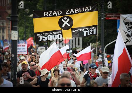 Le persone che detengono bandiere e striscioni vengono viste durante un rally anti-vaccinazione a Varsavia, in Polonia, il 16 giugno 2021. Oltre mille persone hanno marciato dalla Corte Suprema allo Stadio Nazionale, un importante punto di vaccinazione COVID-19 il sabato per protestare contro i passaporti medici che vedono come una forma di segregazione. (Foto di Str/NurPhoto) Foto Stock