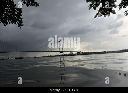 Nubi dense e la riflessione di Vidyasagar setu possono essere viste prima di forti precipitazioni a Kolkata, India, 13 giugno, 2021. (Foto di Indranil Aditya/NurPhoto) Foto Stock