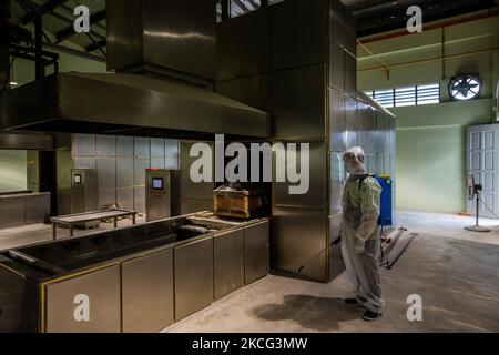 Un lavoratore che indossa la tuta protettiva spruzza disinfettante alla cremazione di zona delle vittime di coronavirus Covid-19 al crematorio Bliss Garden a Shah Alam, Malesia il 15 giugno 2021. (Foto di Mohd Firdaus/NurPhoto) Foto Stock