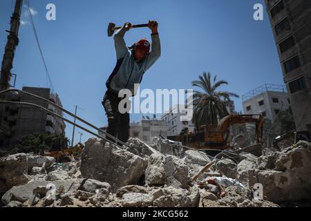 I lavoratori palestinesi e i bulldozer egiziani aiutano il 16 giugno 2021 a rimuovere le macerie delle uildings distrutte dagli attacchi aerei israeliani il mese scorso. - Dopo aver mediato un cessate il fuoco tra israeliani e governanti di Gaza del movimento di Hamas che ha raccolto il peso diplomatico internazionale dell'Egitto, il Cairo sta ora puntando su un progetto di ricostruzione di $500 milioni di dollari per rafforzare la sua influenza politica regionale. Il mese scorso, l'Egitto ha promesso mezzo miliardo di dollari per ricostruire l'enclave palestinese bloccata, che è stata bombardata da Israele per 11 giorni durante pesanti combattimenti con Hamas che si sono conclusi con un intermediario egiziano Foto Stock