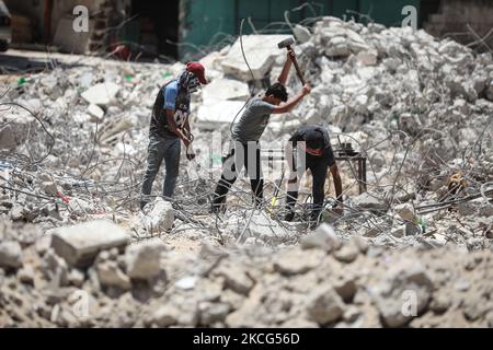 I lavoratori palestinesi e i bulldozer egiziani aiutano il 16 giugno 2021 a rimuovere le macerie delle uildings distrutte dagli attacchi aerei israeliani il mese scorso. - Dopo aver mediato un cessate il fuoco tra israeliani e governanti di Gaza del movimento di Hamas che ha raccolto il peso diplomatico internazionale dell'Egitto, il Cairo sta ora puntando su un progetto di ricostruzione di $500 milioni di dollari per rafforzare la sua influenza politica regionale. Il mese scorso, l'Egitto ha promesso mezzo miliardo di dollari per ricostruire l'enclave palestinese bloccata, che è stata bombardata da Israele per 11 giorni durante pesanti combattimenti con Hamas che si sono conclusi con un intermediario egiziano Foto Stock