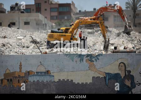 I lavoratori palestinesi e i bulldozer egiziani aiutano il 16 giugno 2021 a rimuovere le macerie delle uildings distrutte dagli attacchi aerei israeliani il mese scorso. - Dopo aver mediato un cessate il fuoco tra israeliani e governanti di Gaza del movimento di Hamas che ha raccolto il peso diplomatico internazionale dell'Egitto, il Cairo sta ora puntando su un progetto di ricostruzione di $500 milioni di dollari per rafforzare la sua influenza politica regionale. Il mese scorso, l'Egitto ha promesso mezzo miliardo di dollari per ricostruire l'enclave palestinese bloccata, che è stata bombardata da Israele per 11 giorni durante pesanti combattimenti con Hamas che si sono conclusi con un intermediario egiziano Foto Stock