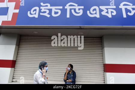 La gente parla al telefono di fronte alla banca HDFC a Kolkata, India, 18 giugno, 2021. HDFC Bank Ltd. Prevede un aumento della spesa IT nei prossimi due o tre anni, poiché il più grande prestatore privato indiano rivende le piattaforme tecnologiche e spruca le offerte digitali dopo aver superato le normative in caso di più problemi, secondo un report dei media indiani. (Foto di Indranil Aditya/NurPhoto) Foto Stock