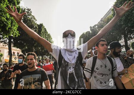 I manifestanti alzano le armi mentre gridano slogan anti-poliziotti durante una manifestazione tenutasi su Avenue Habib Bourguiba a Tunisi, in Tunisia, il 18 giugno 2021, per protestare contro la repressione e l'impunità della polizia. (Foto di Chardy ben Ibrahim/NurPhoto) Foto Stock