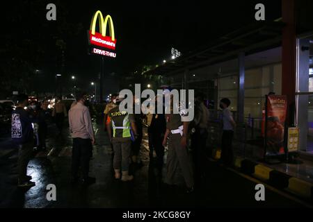 L'ufficiale di supervisione congiunto Covid-19 fa appello ai residenti che si riuniscono e ai luoghi di attività culinarie nell'area di Duren Sawit, a est di Giacarta, il 18 giugno 2021. Il governo di Giacarta attraverso il suo governatore dà consigli in casi di trasmissione Covid-19 è in aumento per restringere tutte le attività che sono limitate a 21,00 pm in tutta Giacarta. (Foto di Dasril Roszandi/NurPhoto) Foto Stock