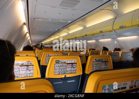 Attentand di volo indossando maschere durante il volo. Volare durante la pandemia di Coronavirus Covid-19 all'interno di un aeromobile Boeing 737-800 di Ryanair low cost con destinazione la Canea nell'isola di Creta, una popolare destinazione di vacanza. All'interno dell'aereo è obbligatorio indossare maschere facciali per i passeggeri e l'equipaggio di volo, la guardia aerea, ecc. mentre le persone hanno bisogno di un test COVID negativo per salire a bordo dell'aereo come misura di sicurezza, mentre l'industria aeronautica e turistica sta lottando per tornare alla normalità. La Grecia sta cercando di incentivare il proprio turismo e concedere privilegi per vaccinare contro il Covid-1 Foto Stock