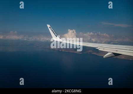 Vista sull'ala con logo RYANAIR mentre atterra sull'isola mediterranea di Creta. Volare durante la pandemia di Coronavirus Covid-19 all'interno di un aeromobile Boeing 737-800 di Ryanair low cost con destinazione la Canea nell'isola di Creta, una popolare destinazione di vacanza. All'interno dell'aereo è obbligatorio indossare maschere facciali per i passeggeri e l'equipaggio di volo, la guardia aerea, ecc. mentre le persone hanno bisogno di un test COVID negativo per salire a bordo dell'aereo come misura di sicurezza, mentre l'industria aeronautica e turistica sta lottando per tornare alla normalità. La Grecia sta cercando di rilanciare il suo turismo e di dare privilegi a v Foto Stock