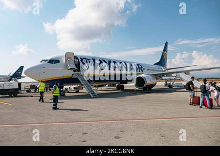 Il Boeing 737 della compagnia Ryanair budget mentre i passeggeri lasciano il posto. Volare durante la pandemia di Coronavirus Covid-19 all'interno di un aeromobile Boeing 737-800 di Ryanair low cost con destinazione la Canea nell'isola di Creta, una popolare destinazione di vacanza. All'interno dell'aereo è obbligatorio indossare maschere facciali per i passeggeri e l'equipaggio di volo, la guardia aerea, ecc. mentre le persone hanno bisogno di un test COVID negativo per salire a bordo dell'aereo come misura di sicurezza, mentre l'industria aeronautica e turistica sta lottando per tornare alla normalità. La Grecia sta cercando di dare impulso al proprio turismo e di concedere privilegi a vaccin Foto Stock