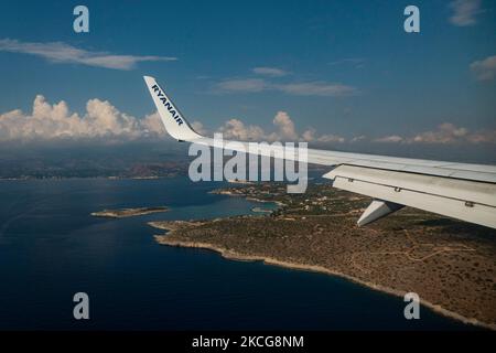 Vista sull'ala con logo RYANAIR mentre atterra sull'isola mediterranea di Creta. Volare durante la pandemia di Coronavirus Covid-19 all'interno di un aeromobile Boeing 737-800 di Ryanair low cost con destinazione la Canea nell'isola di Creta, una popolare destinazione di vacanza. All'interno dell'aereo è obbligatorio indossare maschere facciali per i passeggeri e l'equipaggio di volo, la guardia aerea, ecc. mentre le persone hanno bisogno di un test COVID negativo per salire a bordo dell'aereo come misura di sicurezza, mentre l'industria aeronautica e turistica sta lottando per tornare alla normalità. La Grecia sta cercando di rilanciare il suo turismo e di dare privilegi a v Foto Stock