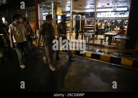 Il covid-19 ufficiale di vigilanza congiunto ha fatto un appello ai residenti che si sono riuniti e luoghi di affari culinari intorno all'area di Duren Sawit, Giacarta orientale, il 18 giugno 2021. Questa attività è stata svolta a causa del caso di trasmissione di covid-19 aumentato e inasprito tutte le attività sono state limitate a 21,00 pm e anche le istruzioni del governatore di Giacarta. (Foto di Dasril Roszandi/NurPhoto) Foto Stock