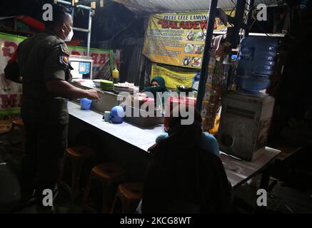 Il covid-19 ufficiale di vigilanza congiunto ha fatto un appello ai residenti che si sono riuniti e luoghi di affari culinari intorno all'area di Duren Sawit, Giacarta orientale, il 18 giugno 2021. Questa attività è stata svolta a causa del caso di trasmissione di covid-19 aumentato e inasprito tutte le attività sono state limitate a 21,00 pm e anche le istruzioni del governatore di Giacarta. (Foto di Dasril Roszandi/NurPhoto) Foto Stock