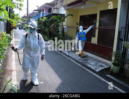 Diversi ufficiali che indossano i dispositivi di protezione individuale (DPI) spray disinfettante in un certo numero di residenze densamente popolate dopo 29 residenti sono stati esposti al virus Covid-19 e 2 persone sono morte a Malang, giava orientale, il 21 giugno 2021. Secondo i dati del Ministero della Salute indonesiano, ci è stato un picco nei casi positivi di COVID-19 che ha raggiunto 1.989.909 persone. Mentre i casi hanno recuperato 1.792.528 persone e il bilancio delle vittime ha raggiunto 54.662 persone il 20 giugno. Di questi casi, 145 persone sono state esposte a 3 nuove varianti del virus Corona (variante Beta, variante Alpha e variante Delta) in Indo Foto Stock