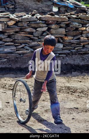 Il ragazzo Ladakhi gioca con una ruota ciclabile in un piccolo villaggio di Rangdum, Ladakh, Jammu e Kashmir, India. (Foto di Creative Touch Imaging Ltd./NurPhoto) Foto Stock