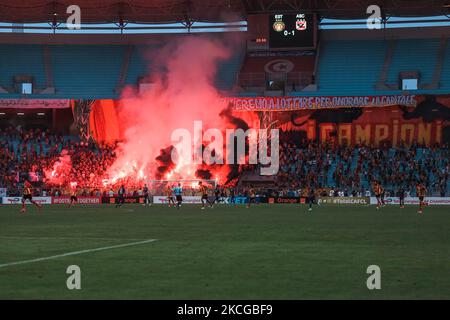 I fan di Esperance Sportive de Tunis illuminano i loro flares mentre fanno il tifo per la loro squadra durante la prima tappa della partita di calcio semifinale della CAF Champions League tra l'Esperance tunisina e al-Ailly dell'Egitto allo Stadio Olimpico di Rades, nella periferia orientale della capitale tunisina Tunisi, il 19 giugno 2021. (Foto di Ahmed Awaad/NurPhoto) Foto Stock