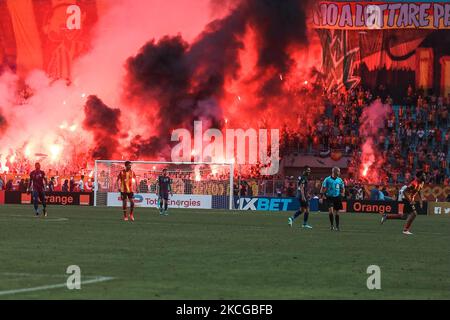 I fan di Esperance Sportive de Tunis illuminano i loro flares mentre fanno il tifo per la loro squadra durante la prima tappa della partita di calcio semifinale della CAF Champions League tra l'Esperance tunisina e al-Ailly dell'Egitto allo Stadio Olimpico di Rades, nella periferia orientale della capitale tunisina Tunisi, il 19 giugno 2021. (Foto di Ahmed Awaad/NurPhoto) Foto Stock