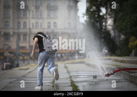 Il 22 giugno 2021 a Varsavia, Polonia, un giovane passa attraverso una fontana di acqua fredda. L’Europa ha subito una prima ondata di caldo che ha costato decine di vite in tutto il paese. In Polonia più di una dozzina di persone sono morte dopo essere state annegate nel fine settimana. Il paese ha visto temperature record con picchi insoliti di 35 gradi in diverse aree. (Foto di Str/NurPhoto) Foto Stock