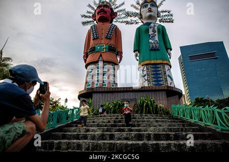 Bambini che indossano maschere facciali vicino alla statua di Ondel-ondel, Giacarta, il 22 giugno 2021. Il governatore di Giacarta Anies Baswedan ha detto che c'è un nuovo modello nel recente aumento dei casi di Covid-19 nella capitale. Secondo lui, il numero di pazienti di Covid-19 tra i bambini è in aumento. È molto probabilmente dovuto ad una nuova variante più contagiosa, anche per i bambini. Ha citato un esempio che domenica 20 giugno la città ha registrato 5.582 nuovi casi e che il 16 per cento di essi erano bambini. (Foto di Afriadi Hikmal/NurPhoto) Foto Stock