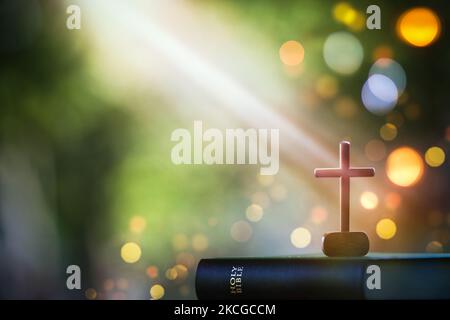 Natale sfondo luminoso con bibbia e crocifissione di Gesù Cristo e luci bokeh sfondo Foto Stock