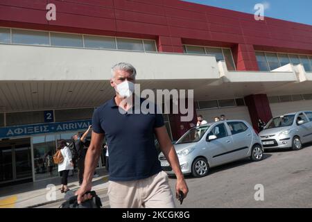 Passeggeri con maschere facciali come visto all'Aeroporto Internazionale di Chania CHQ nell'isola greca di Creta. Creta è una popolare destinazione di viaggio con spiagge famose e fortemente sviluppato settore turistico, con la lunga stagione turistica in quanto si trova nel sud della Grecia, nelle acque del Mediterraneo. La Grecia sta cercando di incentivare il proprio turismo e dare privilegi per vaccinare contro la pandemia di Coronavirus Covid-19 turisti internazionali e locali, poiché il paese è fortemente dipendente dal settore turistico. Il numero di traffico mondiale di passeggeri nel settore dell'aviazione è diminuito a causa delle restrizioni di viaggio, delle misure di sicurezza su Foto Stock