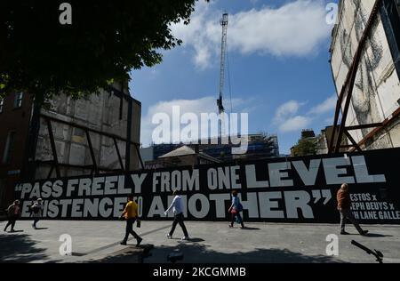 La gente passa davanti a un gigantesco murale 'Pass Freely' di amianto, in collaborazione con la Hugh Lane Gallery, composto da quasi 5.000 partite bruciate disegnate individualmente, ciascuna raffigurante la vita di una persona che è morta da COVID-19 in Irlanda. Mercoledì 30 giugno 2021 a Dublino, Irlanda. (Foto di Artur Widak/NurPhoto) Foto Stock