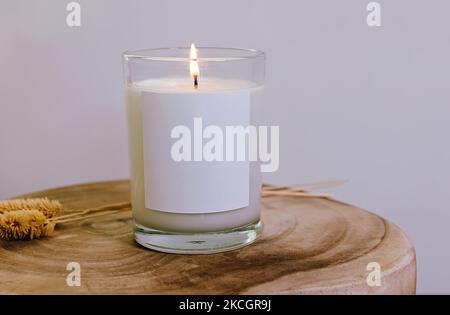Candela bruciante con etichetta bianca vuota primo piano, mock-up. Foto Stock