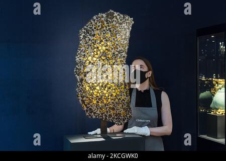 LONDRA, REGNO UNITO - 05 LUGLIO 2021: Un membro dello staff guarda una fetta monolitica del meteorite fukang della provincia di Xinjiang, stima £350.000-£550.000 durante una telefonata fotografica per la Classic Week presso la casa d'aste di Christie, Una serie di nove aste che presentano opere d'arte dall'antichità al 20th° secolo il 05 luglio 2021 a Londra, Inghilterra. (Foto di Wiktor Szymanowicz/NurPhoto) Foto Stock