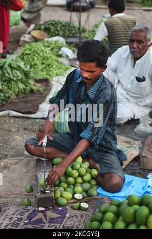 Il commerciante taglia i manghi grezzi per l'uso nel decapaggio al bazar di Subzi di Shaniwaar, che è il più grande mercato della frutta e della verdura nella città indiana di Nagpur, Maharashtra, India. (Foto di Creative Touch Imaging Ltd./NurPhoto) Foto Stock