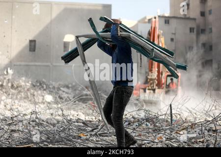 I lavoratori palestinesi raccolgono le macerie della torre al-Jalaa, livellata da uno sciopero aereo israeliano durante il conflitto del maggio 2021 tra Israele e Hamas, per riciclare le macerie a Gaza City il 13 luglio 2021. (Foto di Majdi Fathi/NurPhoto) Foto Stock