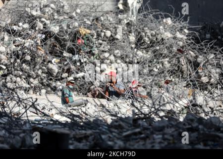 I lavoratori palestinesi raccolgono le macerie della torre al-Jalaa, livellata da uno sciopero aereo israeliano durante il conflitto del maggio 2021 tra Israele e Hamas, per riciclare le macerie a Gaza City il 13 luglio 2021. (Foto di Majdi Fathi/NurPhoto) Foto Stock