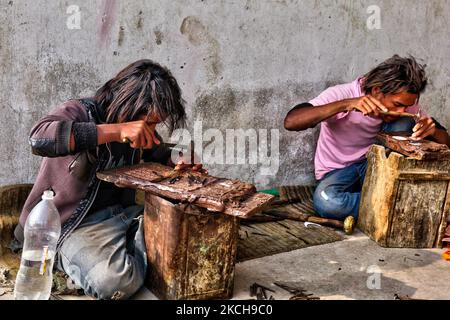 Gli operai di metallo usano uno scalpello per generare i piccoli disegni in un foglio di rame ad un workshop a Kathmandu City, Nepal, il 15 dicembre 2011. (Foto di Creative Touch Imaging Ltd./NurPhoto) Foto Stock