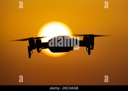 Un quadricottero che sorvola durante un volo di fronte al sole. Il drone volante è visto come una silhouette scura contro lo spettacolare cielo del tramonto colorato e il sole, mentre l'UAV è in grado di catturare la videografia aerea e la fotografia tramite un telecomando. Il drone specifico è un DJI Mavic Air. Il veicolo aereo senza equipaggio è popolare per l'uso ricreativo da parte dei turisti in quanto la tecnologia è accessibile a tutti a basso costo, ma ha anche molte applicazioni professionali sani Beach area, Halkidiki, Grecia il 15 luglio 2021 (Foto di Nicolas Economou/NurPhoto) Foto Stock