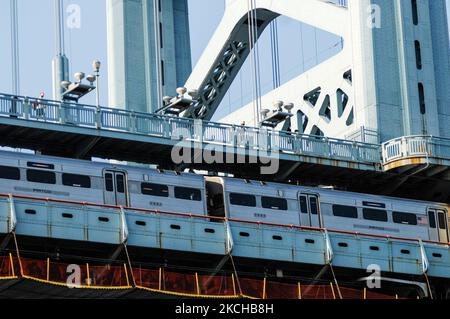 Carlos Aponte e Jason Peters marciano attraverso il ponte Race Street Bridge sulla prima tappa di una marcia di sessantadue miglia da Filadelfia ad Atlantic City mentre un treno PATCO del New Jersey esce da Filadelfia, Per far crescere le voci degli studenti e le organizzazioni della comunità di Philly si sono concentrate sugli studenti nei quartieri più colpiti di Philly, a Filadelfia, PA, il 16 luglio 2021. (Foto di Cory Clark/NurPhoto) Foto Stock