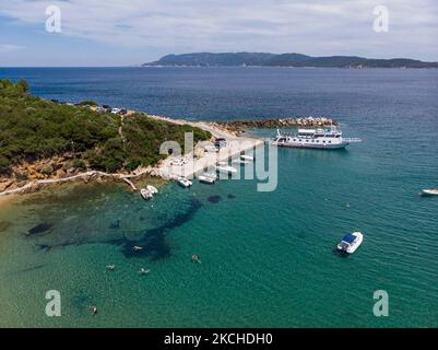 Vista aerea panoramica da un drone di Agios Giorgios o Katigiorgis Village, spiaggia e porto nella regione di Pelion in Grecia con sole durante il periodo estivo. Katigiorgis è un pittoresco villaggio di pescatori a 61km km dalla città di Volos e a 3 miglia nautiche dall'isola di Skiathos che offre una facile opzione per i turisti di visitare le isole Skiathos e Sporades o Pelion con il traghetto. Questo villaggio è piccolo, bello, tranquillo e tranquillo, un paradiso appartato nel Mediterraneo mantenendo il suo stile originale con persone calde, circondato da vegetazione lussureggiante, uliveti e basse colline che hanno solo alcune opzioni per l'ac Foto Stock