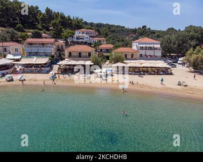 Vista aerea panoramica da un drone di Agios Giorgios o Katigiorgis Village, spiaggia e porto nella regione di Pelion in Grecia con sole durante il periodo estivo. Katigiorgis è un pittoresco villaggio di pescatori a 61km km dalla città di Volos e a 3 miglia nautiche dall'isola di Skiathos che offre una facile opzione per i turisti di visitare le isole Skiathos e Sporades o Pelion con il traghetto. Questo villaggio è piccolo, bello, tranquillo e tranquillo, un paradiso appartato nel Mediterraneo mantenendo il suo stile originale con persone calde, circondato da vegetazione lussureggiante, uliveti e basse colline che hanno solo alcune opzioni per l'ac Foto Stock