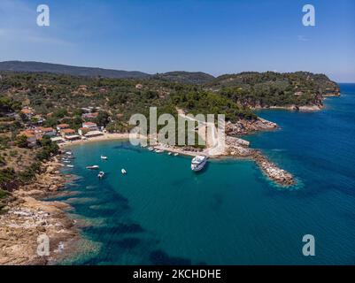 Vista aerea panoramica da un drone di Agios Giorgios o Katigiorgis Village, spiaggia e porto nella regione di Pelion in Grecia con sole durante il periodo estivo. Katigiorgis è un pittoresco villaggio di pescatori a 61km km dalla città di Volos e a 3 miglia nautiche dall'isola di Skiathos che offre una facile opzione per i turisti di visitare le isole Skiathos e Sporades o Pelion con il traghetto. Questo villaggio è piccolo, bello, tranquillo e tranquillo, un paradiso appartato nel Mediterraneo mantenendo il suo stile originale con persone calde, circondato da vegetazione lussureggiante, uliveti e basse colline che hanno solo alcune opzioni per l'ac Foto Stock