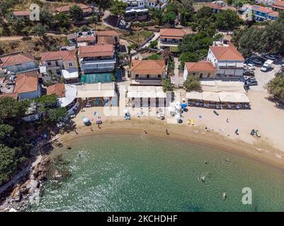 Vista aerea panoramica da un drone di Agios Giorgios o Katigiorgis Village, spiaggia e porto nella regione di Pelion in Grecia con sole durante il periodo estivo. Katigiorgis è un pittoresco villaggio di pescatori a 61km km dalla città di Volos e a 3 miglia nautiche dall'isola di Skiathos che offre una facile opzione per i turisti di visitare le isole Skiathos e Sporades o Pelion con il traghetto. Questo villaggio è piccolo, bello, tranquillo e tranquillo, un paradiso appartato nel Mediterraneo mantenendo il suo stile originale con persone calde, circondato da vegetazione lussureggiante, uliveti e basse colline che hanno solo alcune opzioni per l'ac Foto Stock